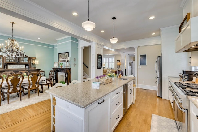 kitchen featuring a sink, appliances with stainless steel finishes, light wood-style floors, and white cabinetry