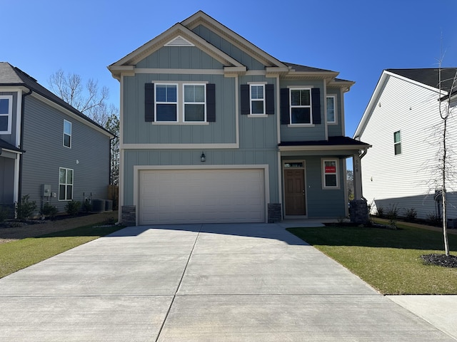 craftsman house with an attached garage, central AC, concrete driveway, board and batten siding, and a front yard