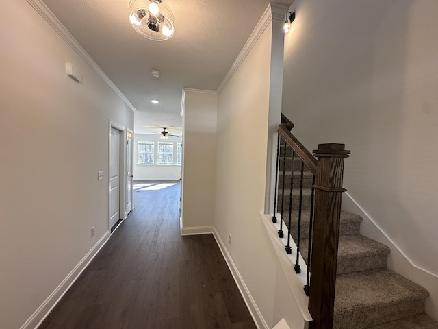 staircase with crown molding, baseboards, and wood finished floors