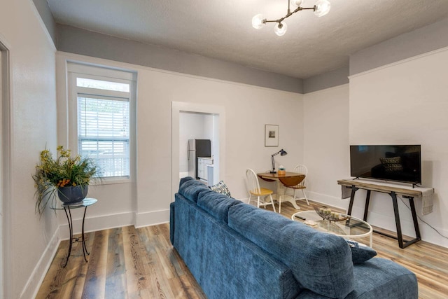 living room featuring hardwood / wood-style floors, a textured ceiling, and a notable chandelier