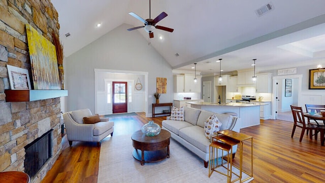 151 Cypress Dr, Mccormick, SC 29835 - living room featuring a stone fireplace, high vaulted ceiling, sink, ceiling fan, and light wood-type flooring