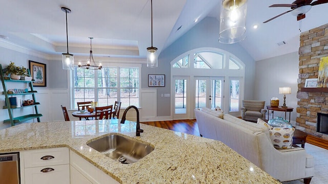 151 Cypress Dr, Mccormick, SC 29835 - kitchen featuring a stone fireplace, white cabinetry, decorative light fixtures, stainless steel dishwasher, and light stone countertops