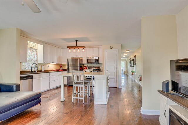 2010 Battle, Augusta, GA 30904 - kitchen featuring stainless steel appliances, a kitchen breakfast bar, white cabinets, tasteful backsplash, and wood-type flooring
