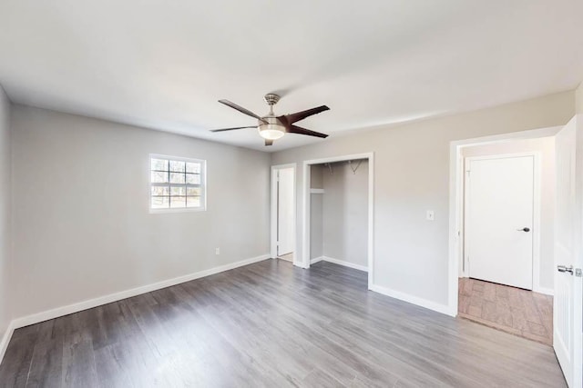 unfurnished bedroom with dark hardwood / wood-style flooring, a closet, and ceiling fan