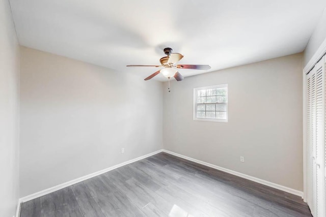 unfurnished bedroom with dark hardwood / wood-style floors, a closet, and ceiling fan