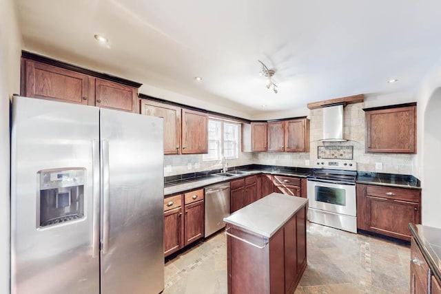 kitchen featuring sink, appliances with stainless steel finishes, a kitchen island, wall chimney range hood, and backsplash