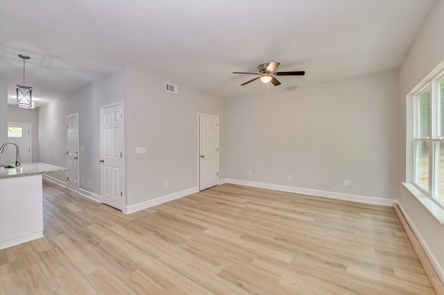 2813 Ridgecrest Dr, Hephzibah, GA 30815 - unfurnished living room featuring plenty of natural light, light wood-style flooring, a ceiling fan, and a baseboard heating unit