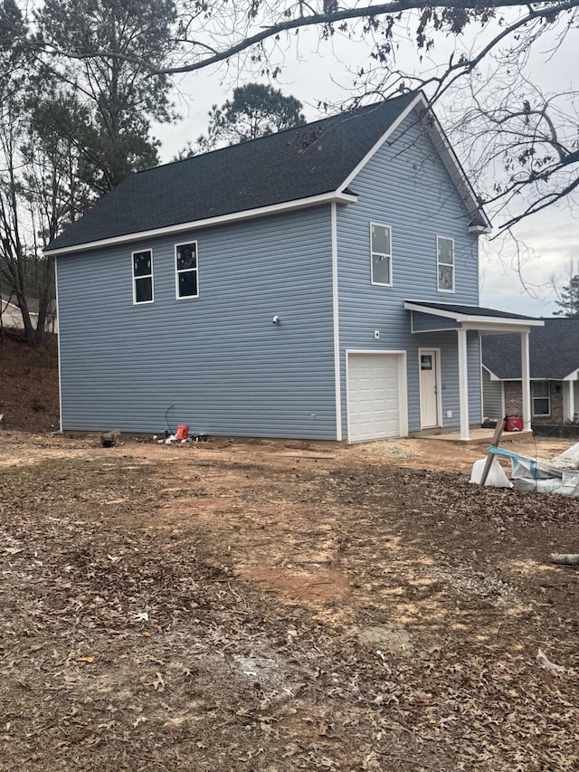 back of property with driveway and an attached garage