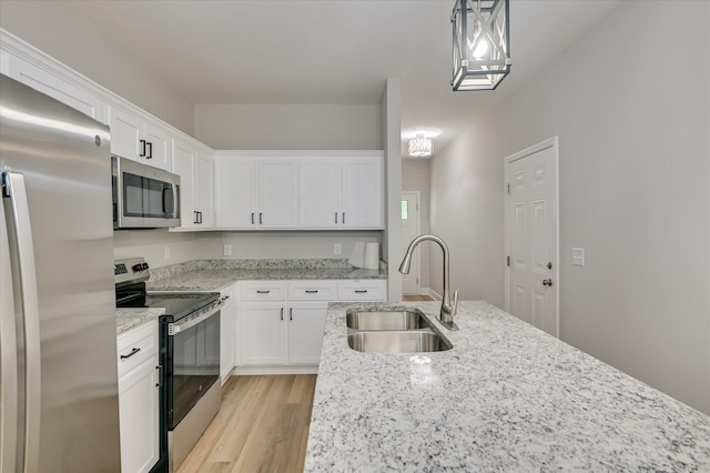 2813 Ridgecrest Dr, Hephzibah, GA 30815 - kitchen with appliances with stainless steel finishes, light wood finished floors, white cabinetry, light stone countertops, and hanging light fixtures