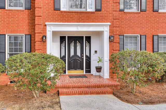 entrance to property featuring brick siding