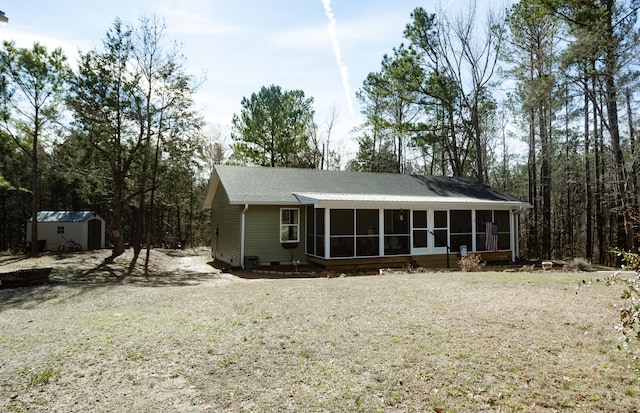 rear view of house featuring a shed and a sunroom