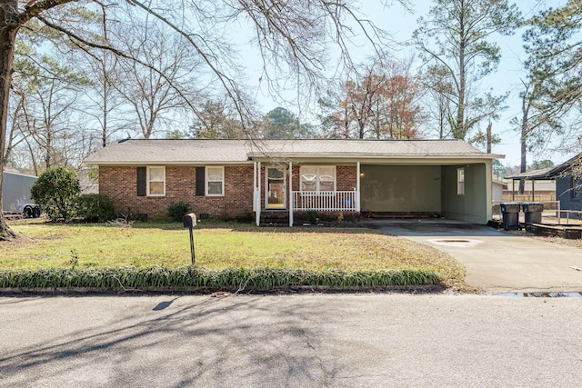 view of front of property with brick siding, concrete driveway, a front yard, covered porch, and a carport