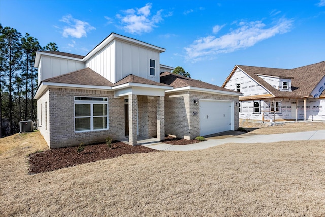 view of front of house featuring a garage, a front yard, and central air condition unit