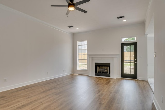 unfurnished living room featuring crown molding, ceiling fan, wood finished floors, a fireplace with flush hearth, and baseboards