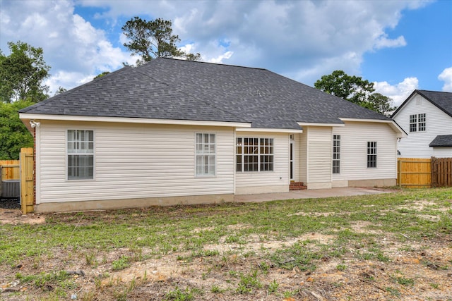rear view of property featuring a patio and a shingled roof