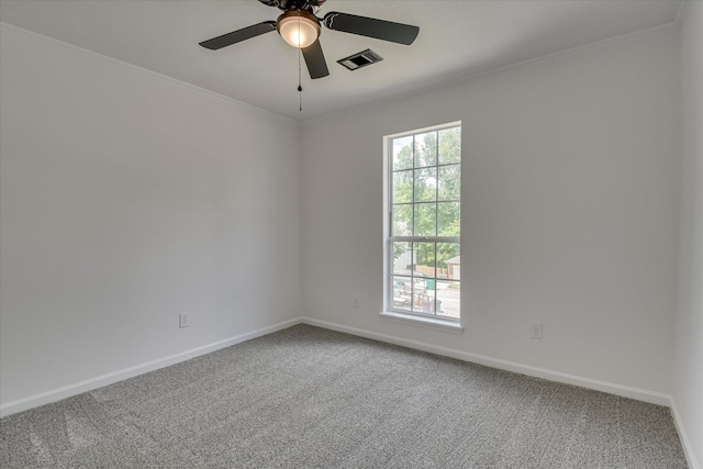 carpeted spare room featuring baseboards, ceiling fan, and crown molding