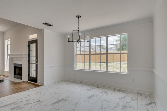 unfurnished dining area featuring marble finish floors, healthy amount of natural light, baseboards, and crown molding