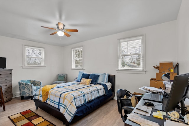 bedroom featuring multiple windows, ceiling fan, and light wood-type flooring