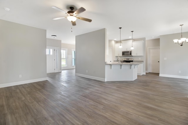 unfurnished living room with sink, dark hardwood / wood-style floors, and ceiling fan with notable chandelier