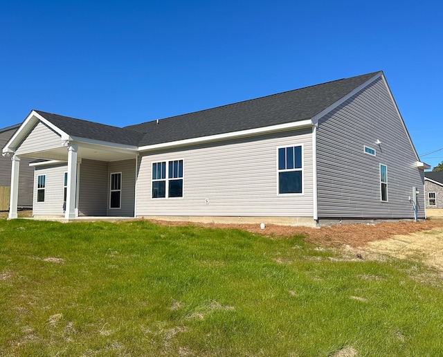 rear view of property featuring a yard