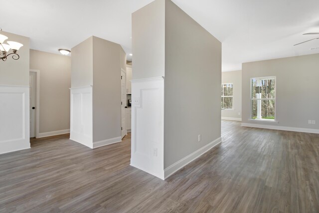 unfurnished room featuring dark wood-type flooring and a notable chandelier