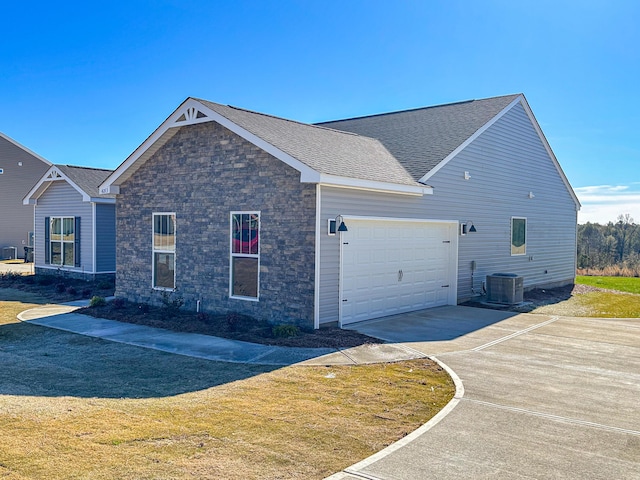 view of home's exterior with a garage, a lawn, and central air condition unit