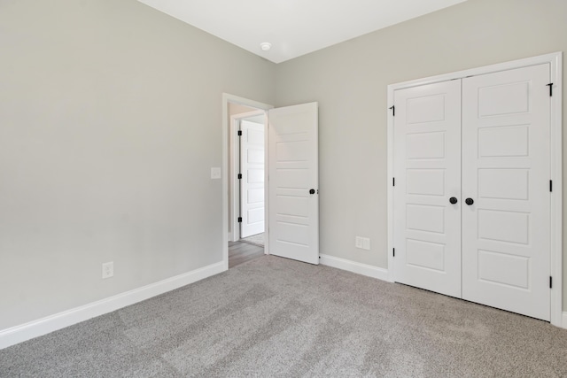 unfurnished bedroom featuring light colored carpet and a closet