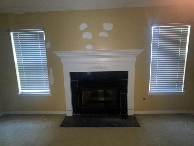 interior details featuring carpet and a tile fireplace