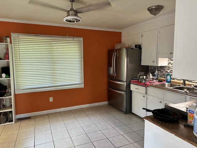 kitchen with white cabinets, decorative backsplash, a textured ceiling, and crown molding