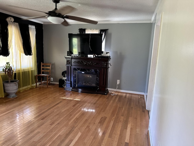 unfurnished living room with hardwood / wood-style flooring, ceiling fan, a fireplace, and a textured ceiling