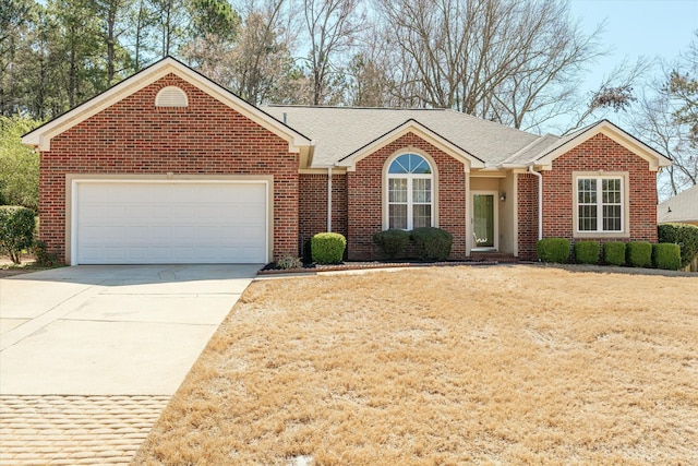 ranch-style house with a garage, brick siding, roof with shingles, and concrete driveway