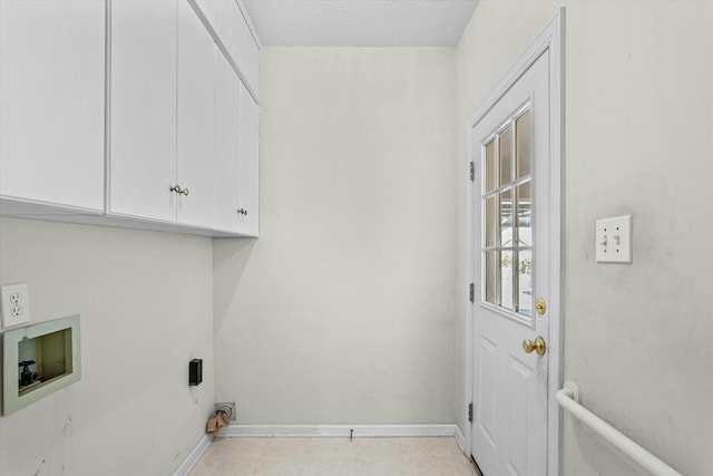 laundry area featuring baseboards, light floors, washer hookup, cabinet space, and a textured ceiling