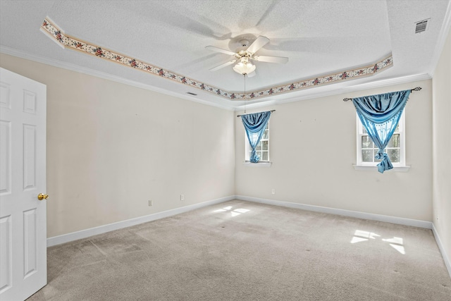 carpeted empty room featuring a raised ceiling, crown molding, visible vents, and a textured ceiling