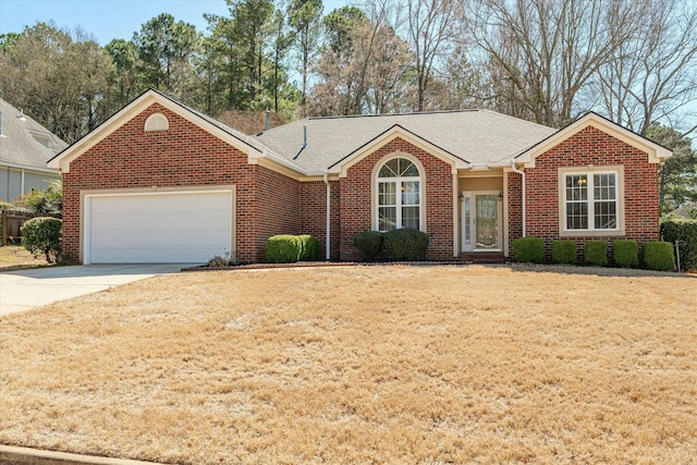 ranch-style house featuring brick siding, an attached garage, concrete driveway, and a front yard