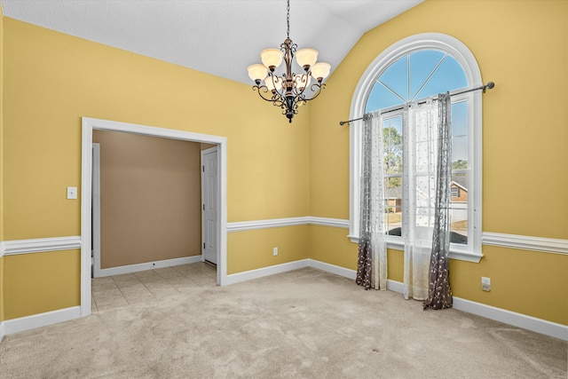 carpeted empty room featuring a notable chandelier, baseboards, and vaulted ceiling