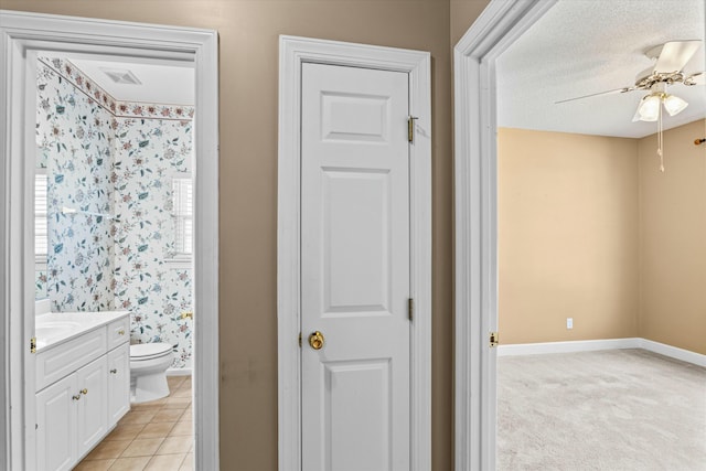 bathroom with vanity, baseboards, visible vents, ceiling fan, and toilet