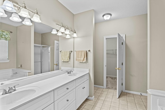 full bath featuring tile patterned flooring, a stall shower, double vanity, and a sink