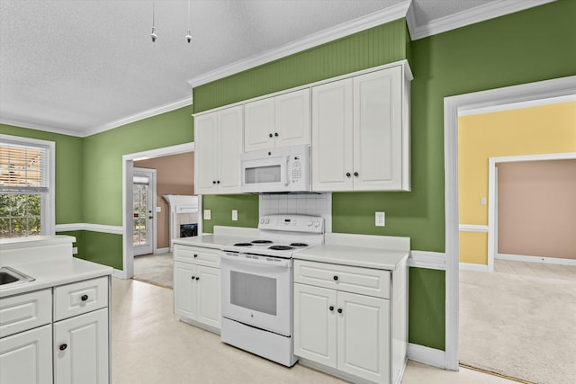 kitchen featuring white appliances, light countertops, white cabinets, a textured ceiling, and crown molding