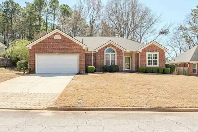 ranch-style house featuring concrete driveway, a garage, fence, and brick siding