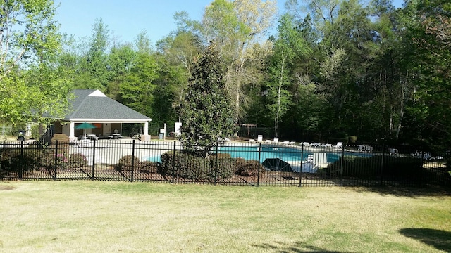 community pool featuring a patio area, fence, and a lawn