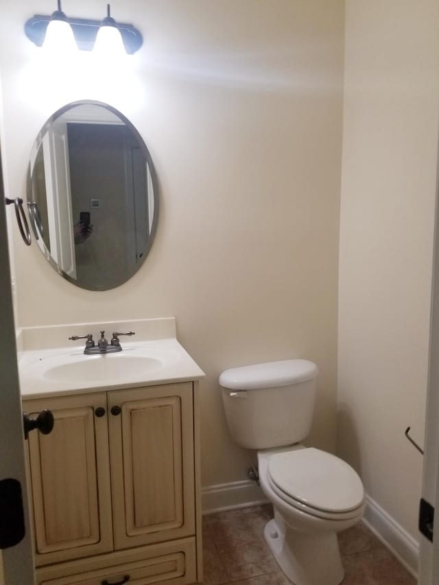 bathroom featuring baseboards, vanity, toilet, and tile patterned floors