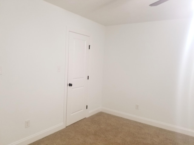 unfurnished room with light colored carpet, ceiling fan, and baseboards