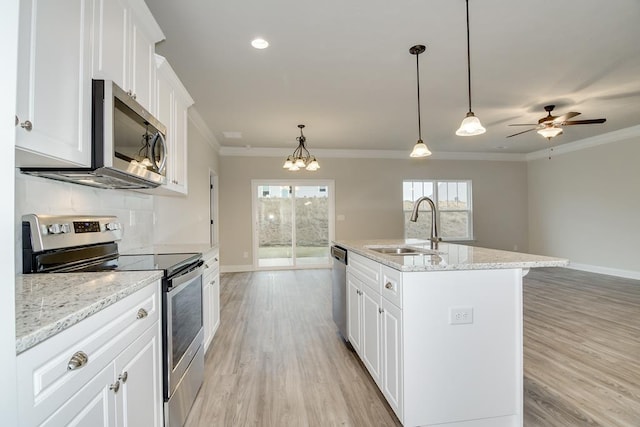 kitchen with sink, decorative light fixtures, an island with sink, stainless steel appliances, and white cabinets