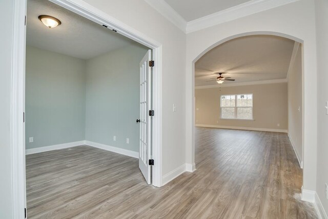 empty room featuring ornamental molding, light hardwood / wood-style floors, and ceiling fan