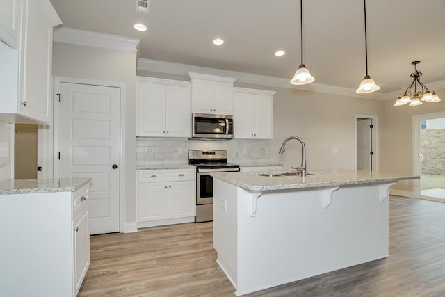 kitchen with white cabinetry, appliances with stainless steel finishes, sink, and hanging light fixtures