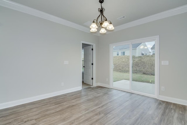 empty room featuring crown molding, a chandelier, and light hardwood / wood-style flooring