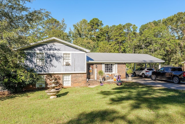 tri-level home featuring metal roof, an attached carport, a front lawn, and brick siding