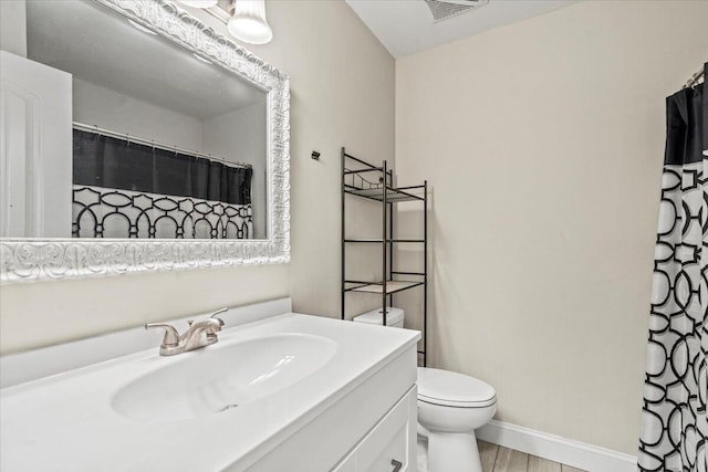 full bathroom with visible vents, toilet, wood finished floors, baseboards, and vanity