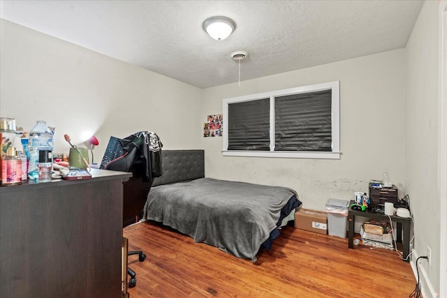 bedroom with wood finished floors and a textured ceiling