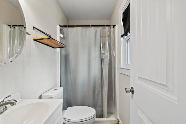 bathroom with toilet, vanity, and a shower with curtain